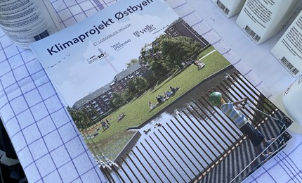 Brochure om klimaprojekt Østbyen på et bord